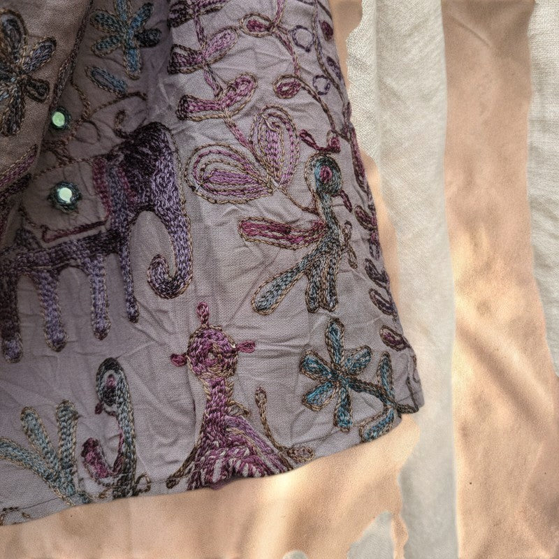 Valentina Dusk Caravan wrap skirt in blue-grey fabric with intricate aubergine hand-embroidered elephant motifs