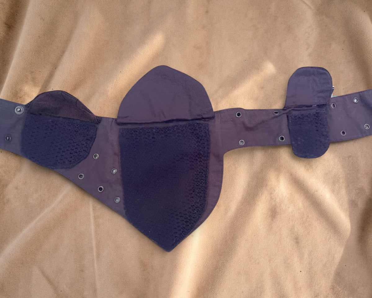 Valentina Nomad plum-colored waist bag featuring intricate crochet textures, lace details, and multiple storage pockets.