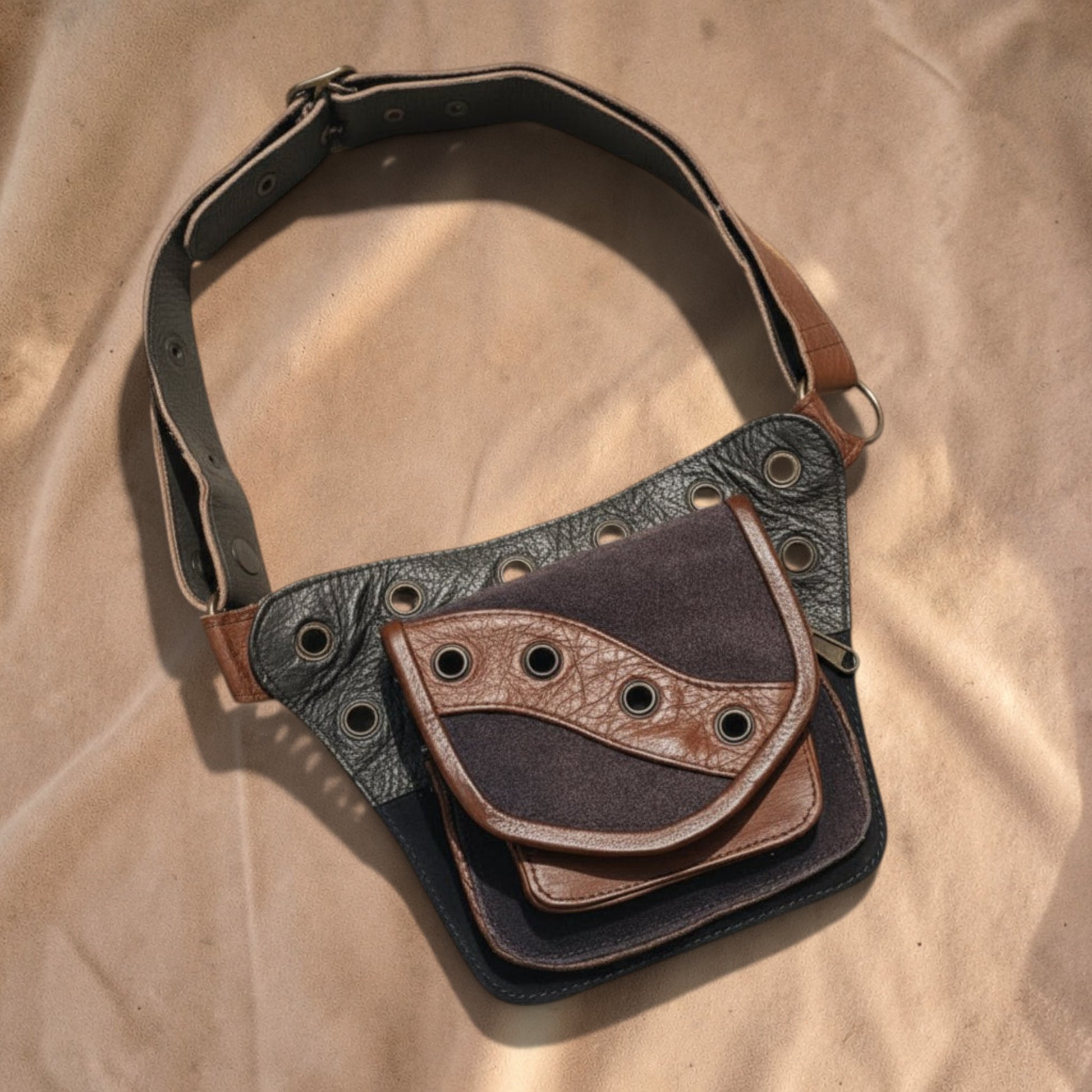 Valentina Artisan heuptas in bruin en zwart leer met metalen details, verstelbare band en meerdere opbergvakken.