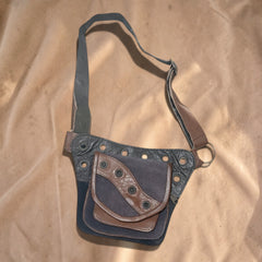 Valentina Artisan heuptas in bruin en donkerblauw leer met metalen details, verstelbare band en meerdere opbergvakken.