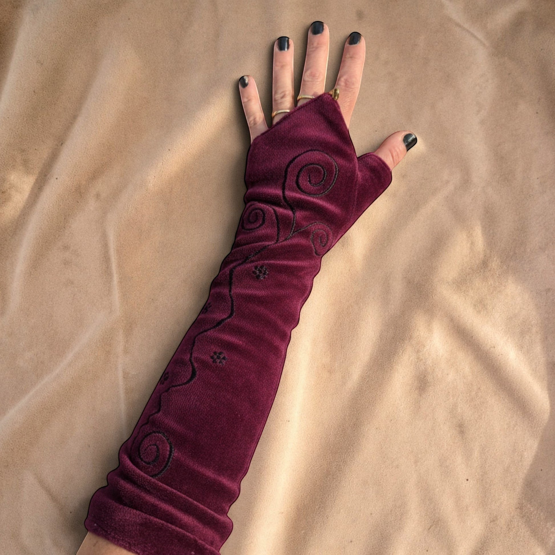 Valentina Ritual Spiral armwarmers in bordeauxrood velvet met geborduurde spiraalpatronen en duimgat.