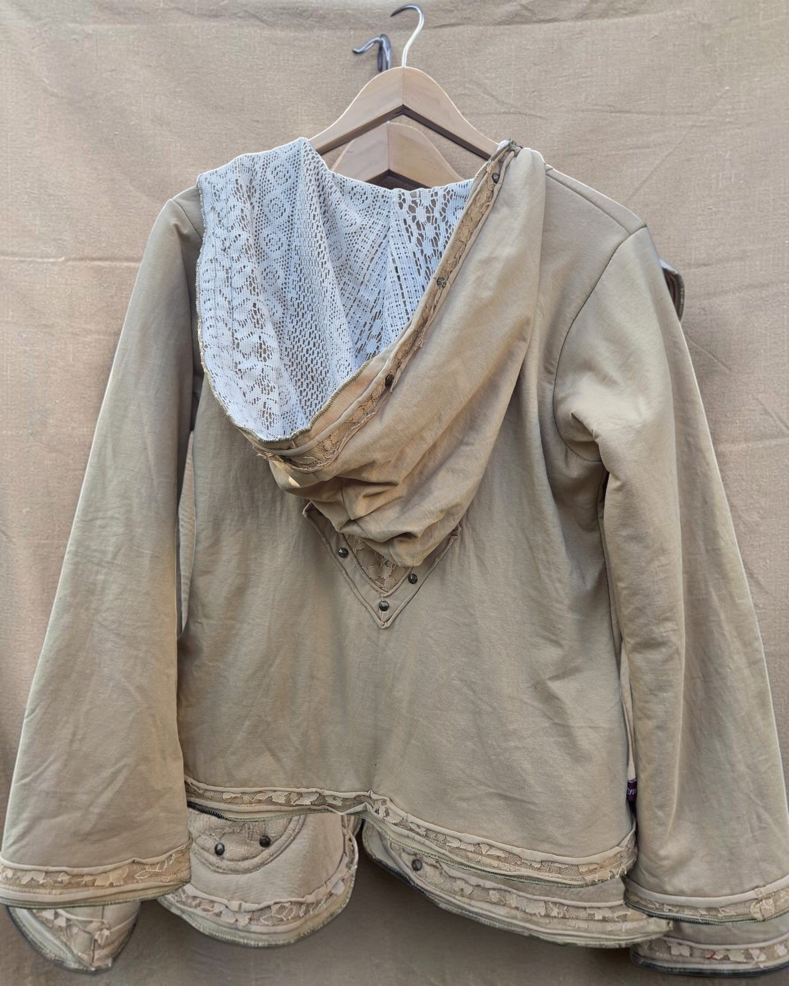 Valentina dames hoodie in beige met kanten details op de capuchon en zoom, versierd met knopen en kant.