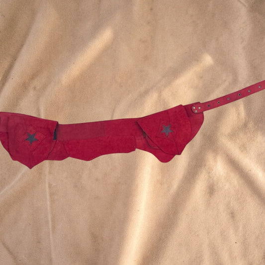 Valentina Firelight red suede waist bag with asymmetrical flaps, star detailing, and an adjustable belt strap.