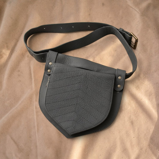 Valentina leaf-shaped grey leather waist bag with adjustable strap and stitched chevron pattern details.