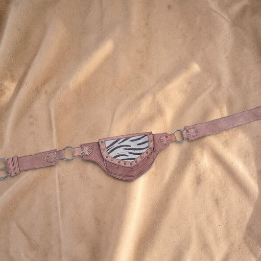 Valentina leather waist bag with zebra print flap, adjustable strap, and metal hardware details on a tan background.