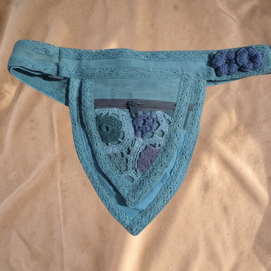 Valentina Nomad Weave fanny pack in teal with unique crochet floral details, pointed shape, and adjustable strap.