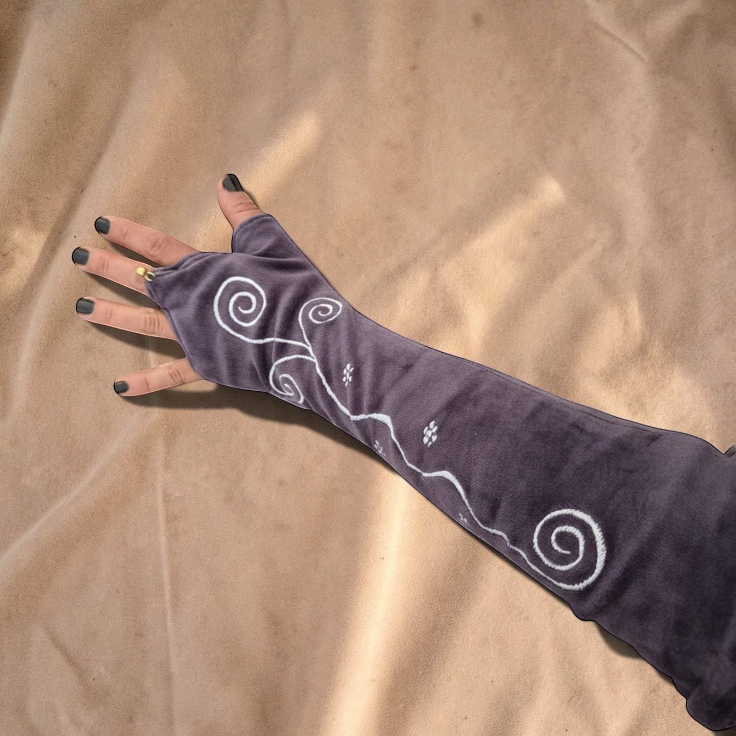 Valentina Ritual Spiral armwarmers in paars velvet met witte geborduurde spiraalpatronen en vingeropening.