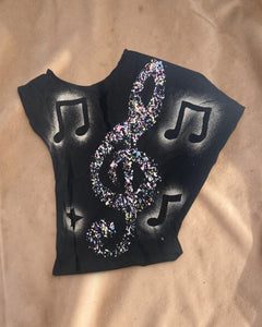 Valentina Rhythm Dust top met zwarte basis, kleurrijke muzieknootprint en brede halslijn voor een losse pasvorm.