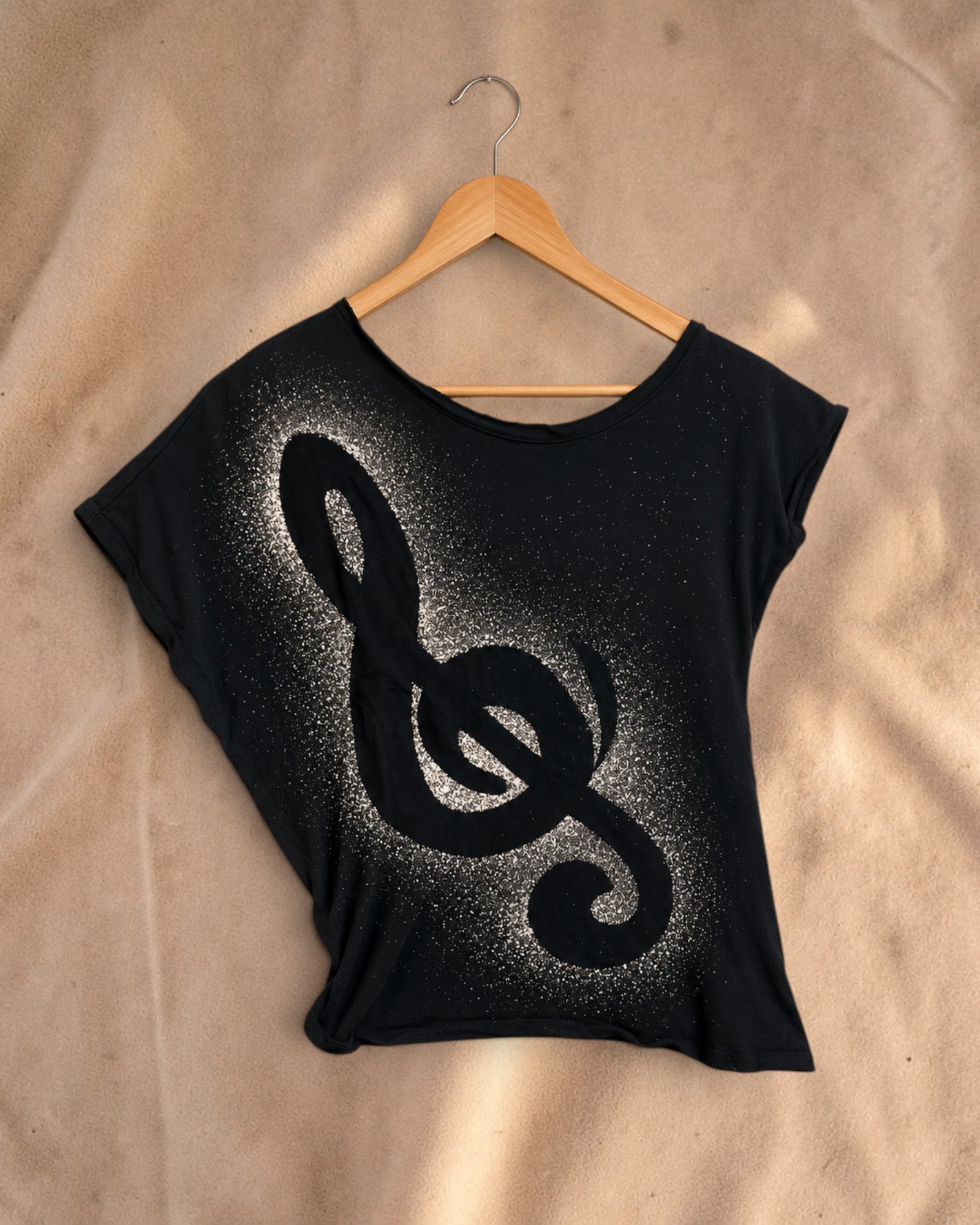 Valentina Rhythm Dust Top in zwart met witte muzieksleutel print en brede halslijn op een houten hanger