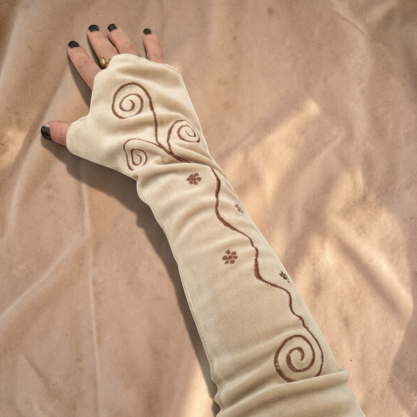 Valentina Ritual Spiral armwarmers in beige velvet met bruine geborduurde spiraalpatronen en duimgat.