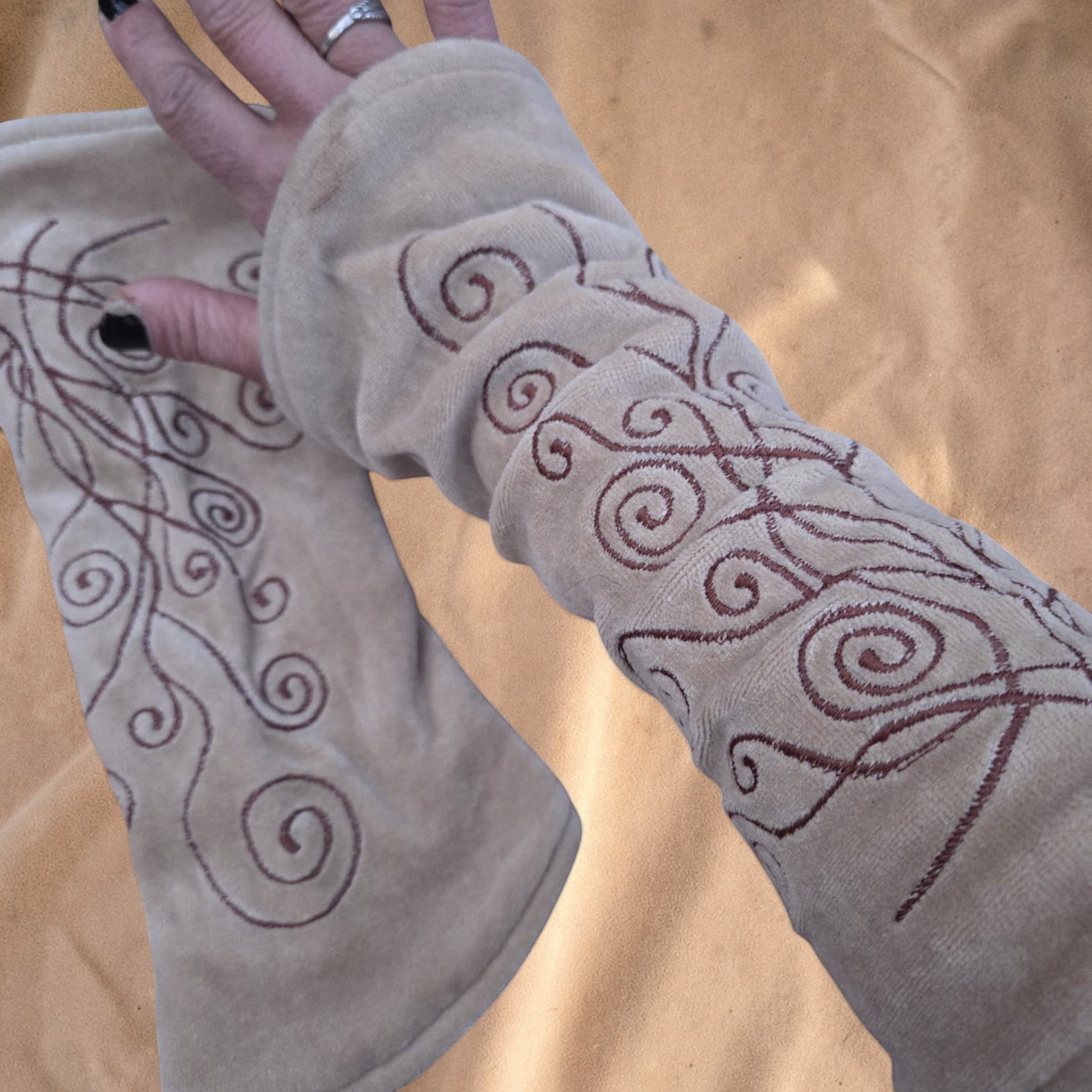Valentina Ritual Spiral armwarmers in beige velvet met bruine geborduurde spiraalpatronen en een zachte pasvorm.