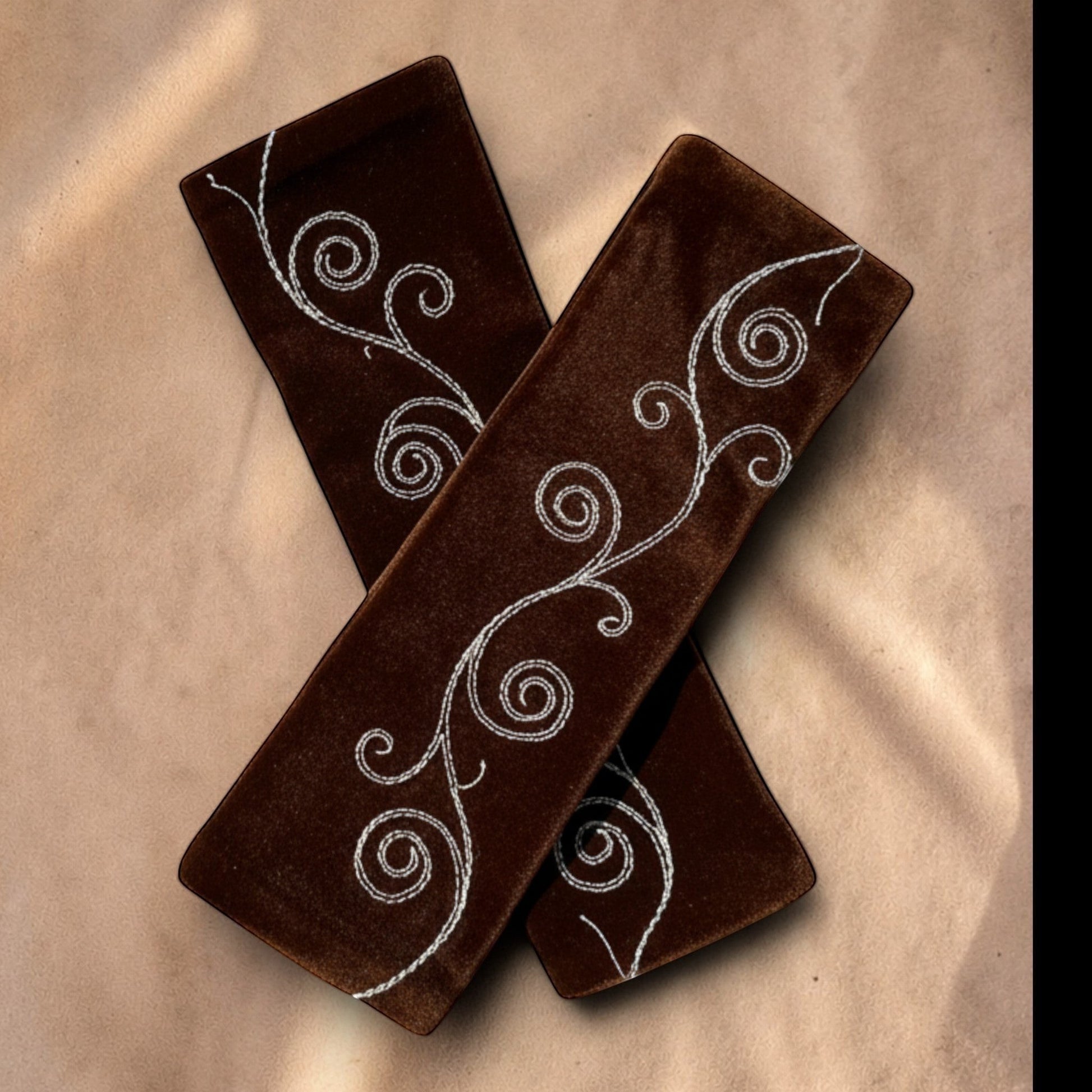 Valentina Ritual Spiral armwarmers van bruin velvet met wit geborduurde spiraalpatronen voor een stijlvolle look.