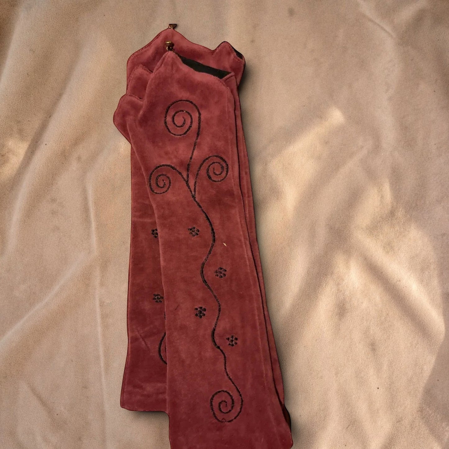 Valentina Ritual Spiral armwarmers in rood velvet met zwarte geborduurde spiraalpatronen en een zachte stretchstof.