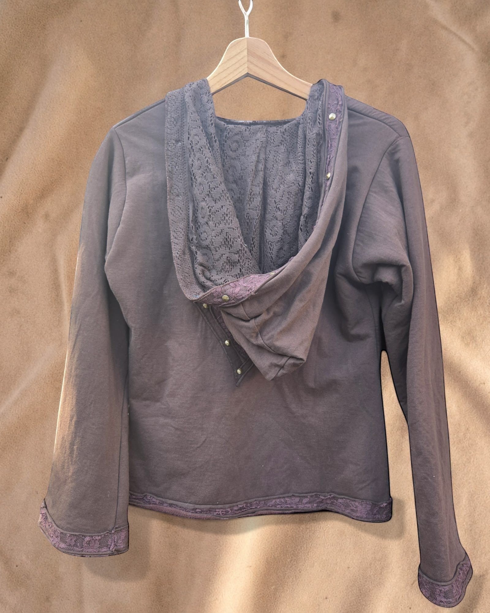 Valentina Soft Nomad Jacket in bruin met kanten details op de capuchon en mouwen, hangend aan een kledinghanger.