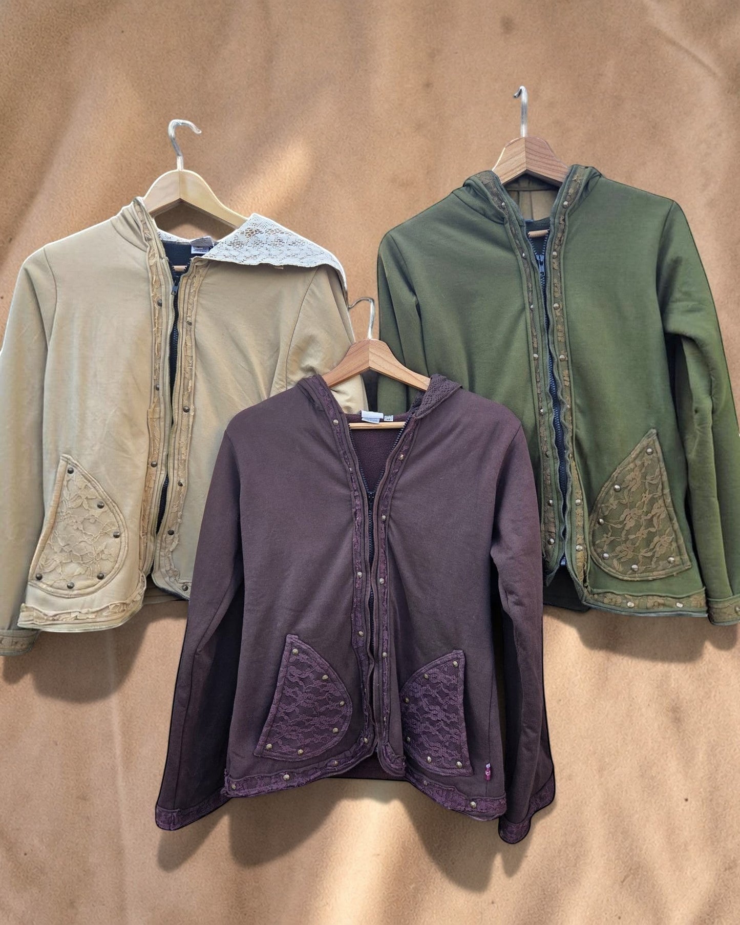 Valentina Soft Nomad jacks in beige, olijfgroen en donkerbruin met kanten details en capuchon op kledinghangers
