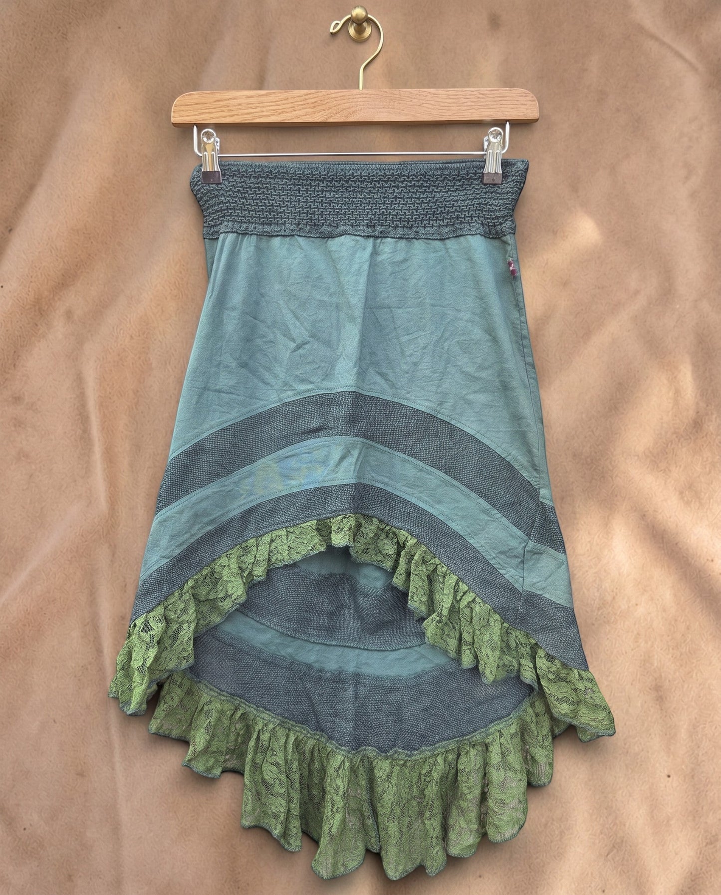 Valentina Woodland Whisper rok in saliegroen met asymmetrische zoom, kanten details en elastische tailleband.
