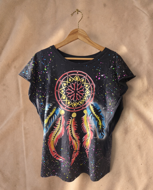 Valentina zwarte Dreamcatcher top met kleurrijke verfspatten, muzieknoten en sterrenprint op een houten hanger.